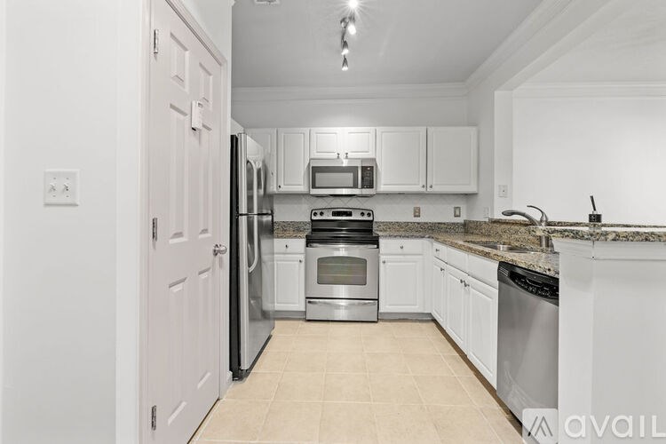 A kitchen with white cabinets and appliances.