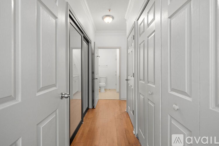 A hallway with white doors and wooden floors.