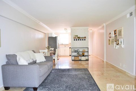 A living room with a grey couch and a grey rug.