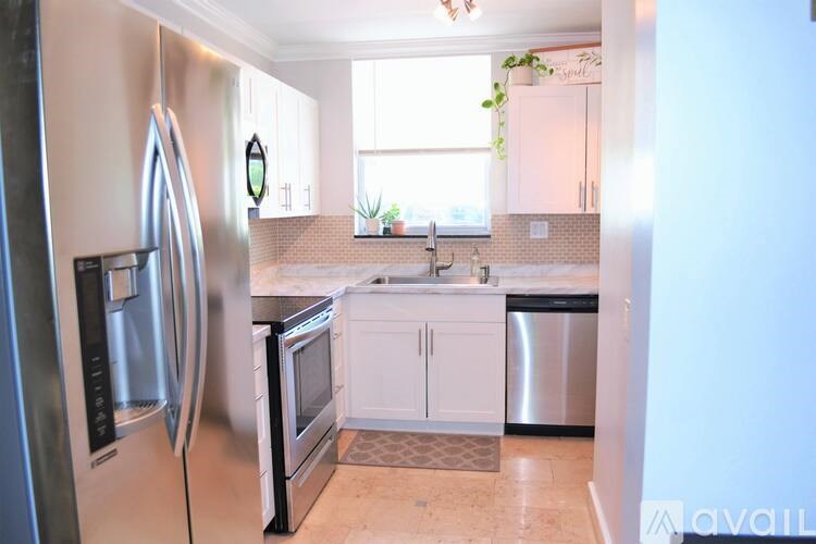 A kitchen with a refrigerator, microwave, oven, and sink.