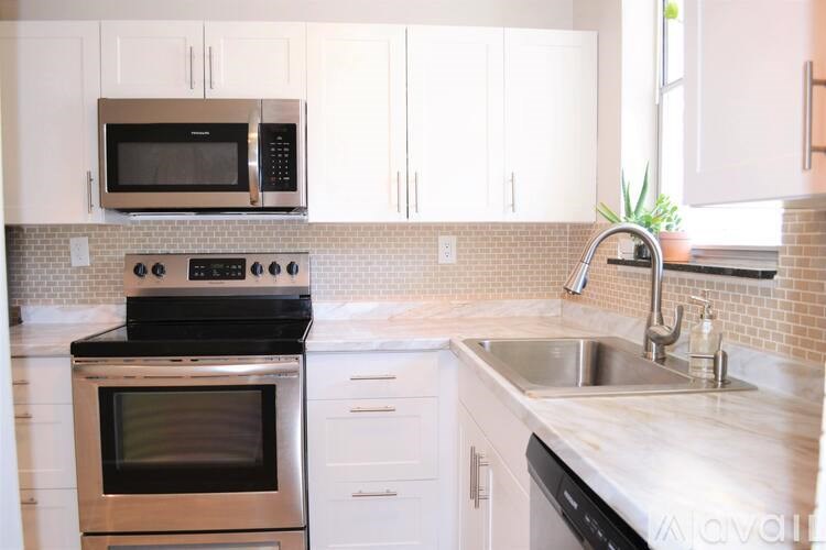 A kitchen with white cabinets and a black stove top oven.