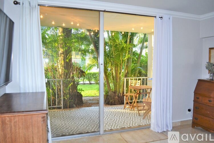 A room with a sliding glass door leading to a garden.