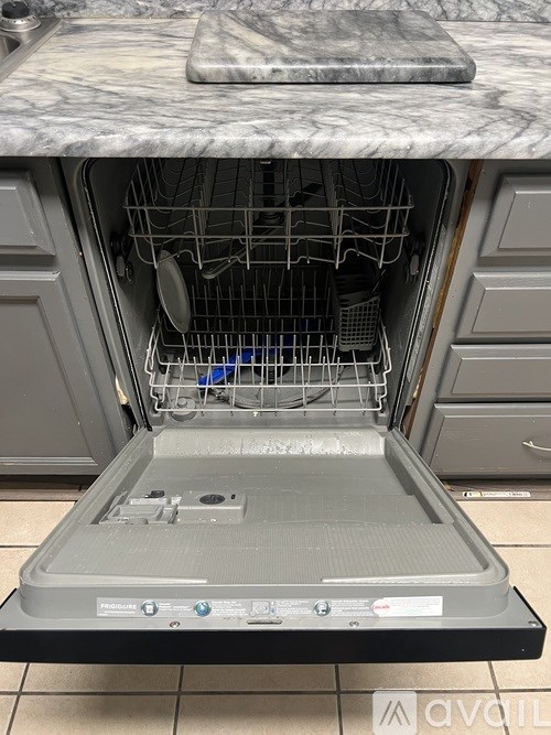A clean oven with the door open and a marble countertop above it.