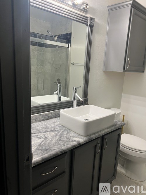 A bathroom with a marble countertop and a white sink.
