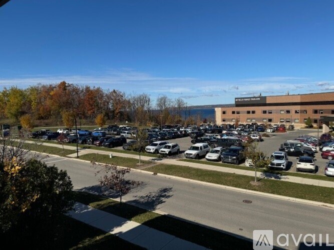 A parking lot with cars and a building in the background.