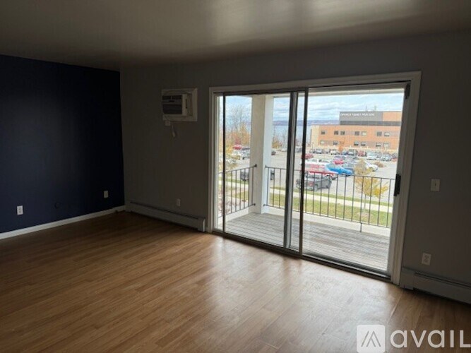 A room with a sliding glass door leading to a parking lot.