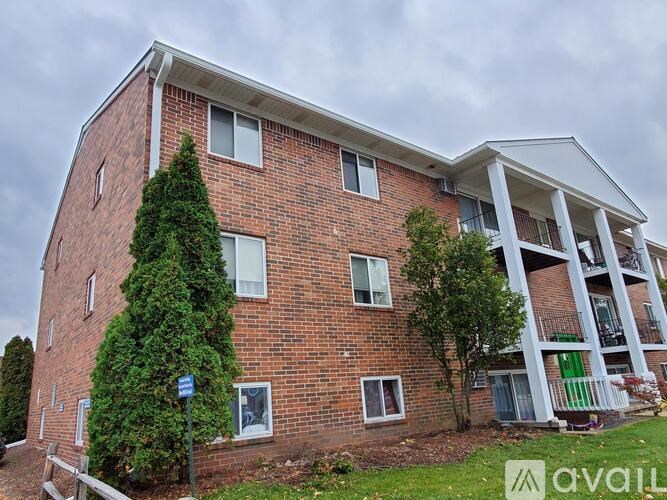A red brick building with a white trim and a balcony on the second floor.