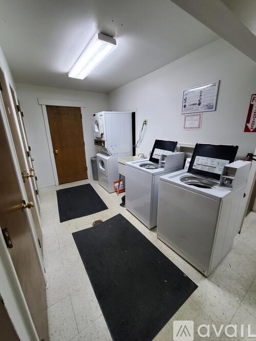 A room with a white fridge, a white microwave, and a white oven.