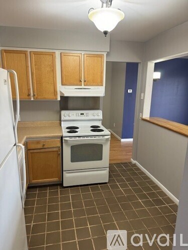 A kitchen with a white stove and a white refrigerator.