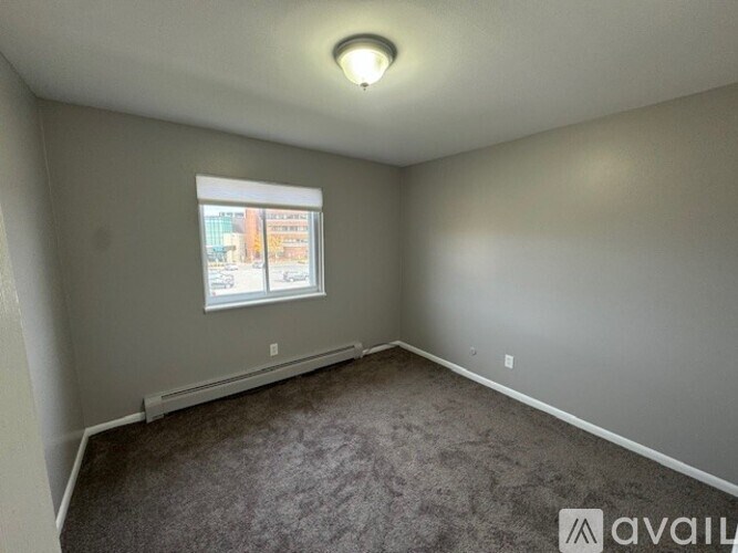 A room with a window and carpeted floor.