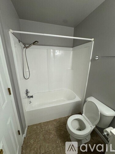 A bathroom with a toilet, tub, and shower.