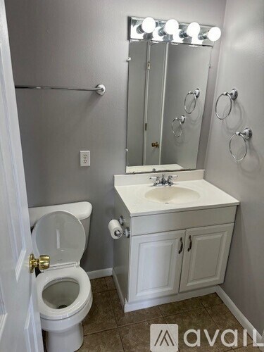 A bathroom with a toilet, sink, and mirror.