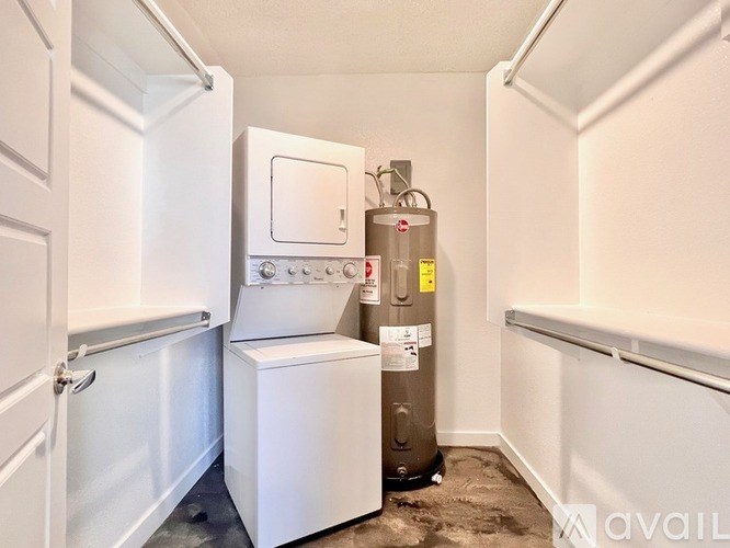 A small white refrigerator is in a corner of a room with a floor heater.