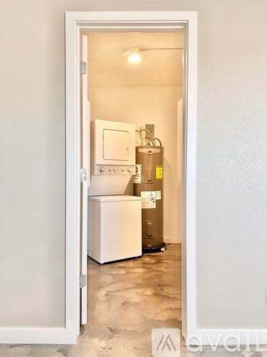 A small kitchen with a white fridge and a white door.