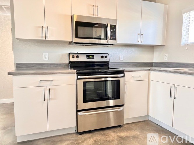 A kitchen with a stove, oven, microwave, and cabinets.