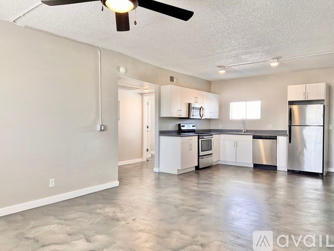 A spacious kitchen with stainless steel appliances and white cabinets.