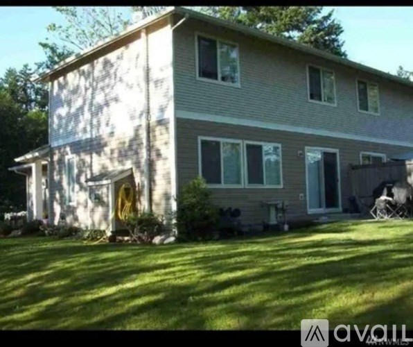 A house with a yellow door and a grey siding is shown.