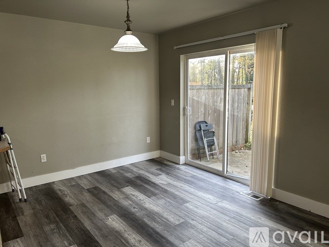 A room with a sliding glass door leading to a backyard.