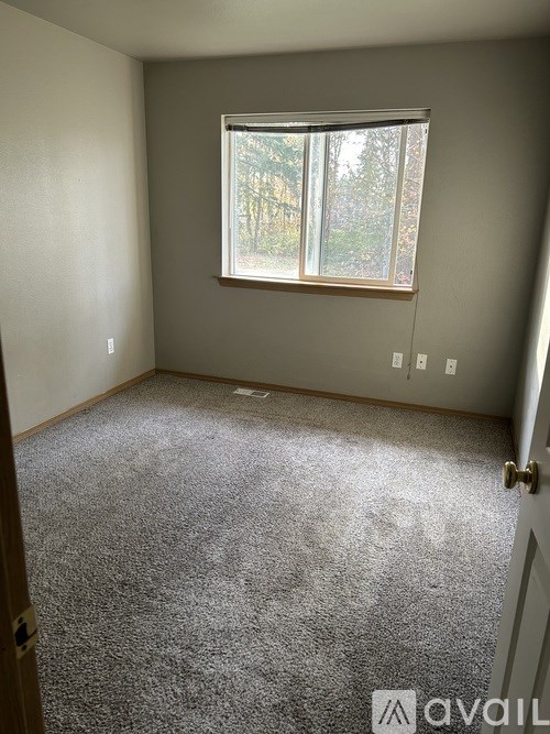 A room with a carpeted floor and a window.