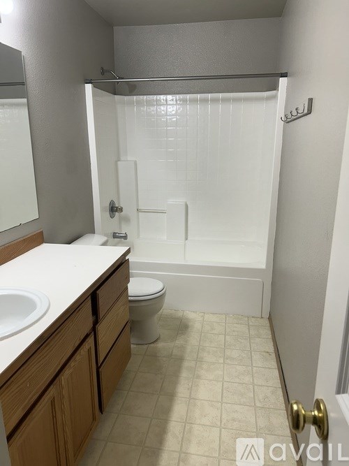 A bathroom with a toilet, sink, and shower.