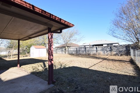 A patio with a red roof and a concrete floor.