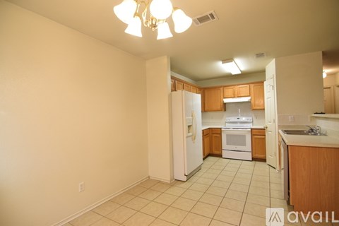 A kitchen with white appliances and wooden cabinets.