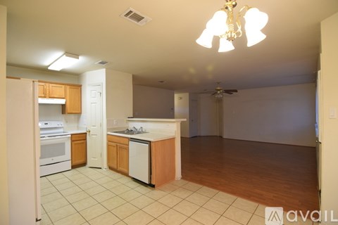 A kitchen with white appliances and wooden cabinets.
