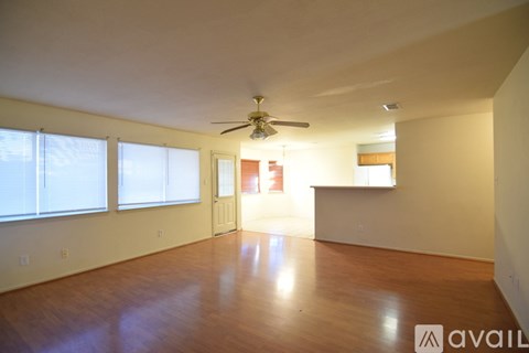 Empty room with a ceiling fan and wooden flooring.
