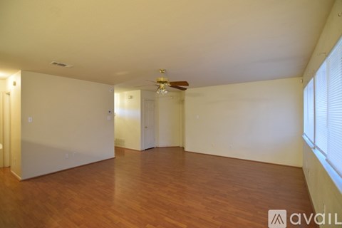 A room with wooden floors and a ceiling fan.