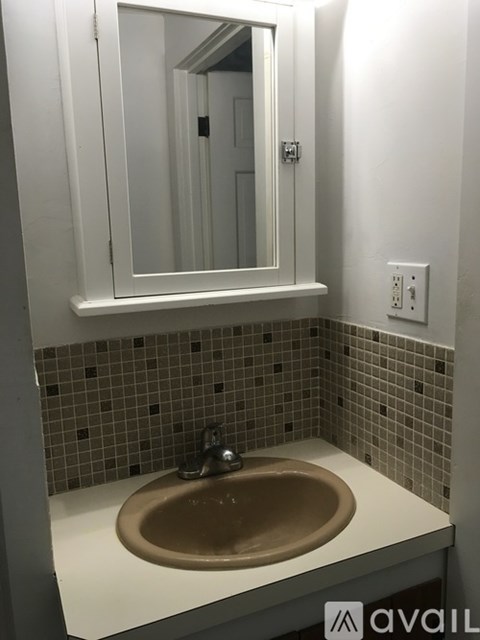 A bathroom sink with a brown basin and a mirror above it.
