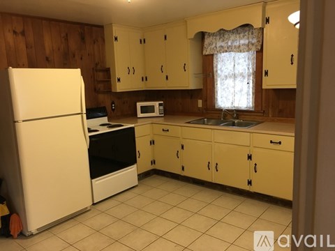 A kitchen with wooden cabinets and a white refrigerator.