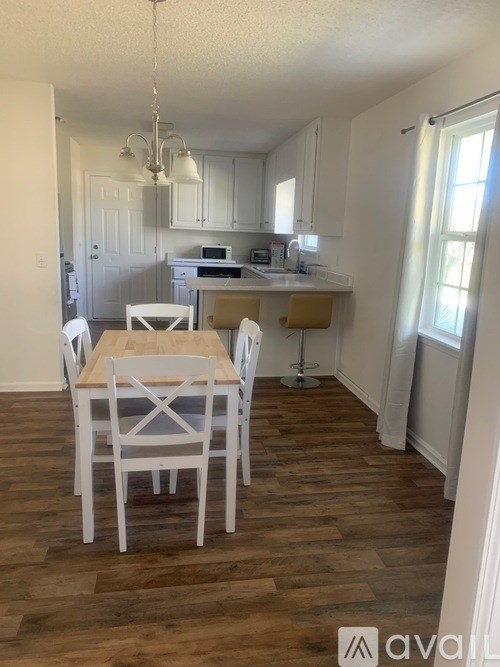 A kitchen with a table and chairs in the foreground.
