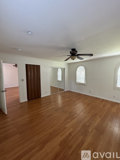 A room with wooden floors and a ceiling fan.