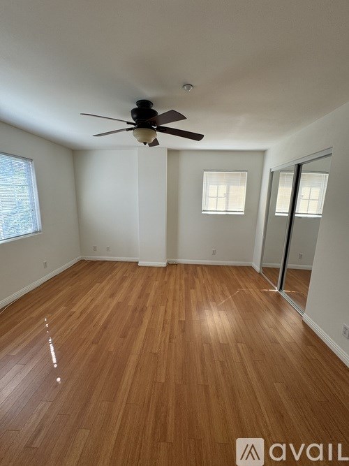 A room with wooden flooring and a ceiling fan.