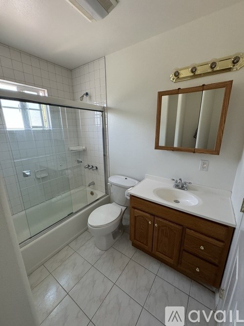 A bathroom with a toilet, sink, and shower.