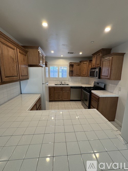 A kitchen with wooden cabinets and a tiled floor.