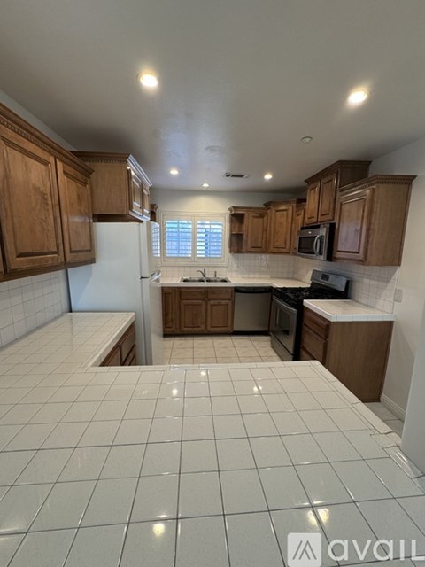 A kitchen with wooden cabinets and a tiled floor.