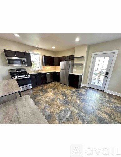 A kitchen with a granite countertop and a refrigerator.
