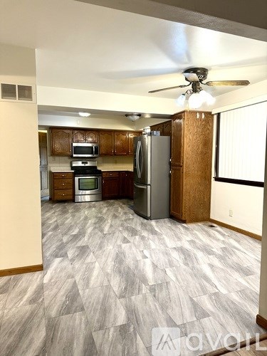 A kitchen with wooden cabinets and a refrigerator.