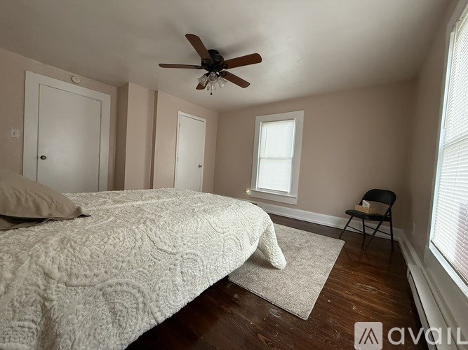 A bedroom with a large bed and a ceiling fan.