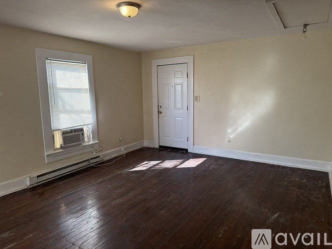 A room with a wooden floor and a white door.