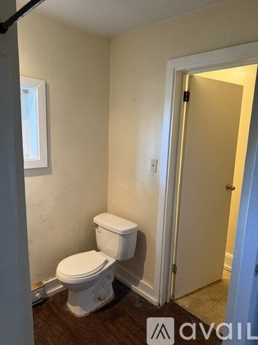 A white toilet in a small room with a door.