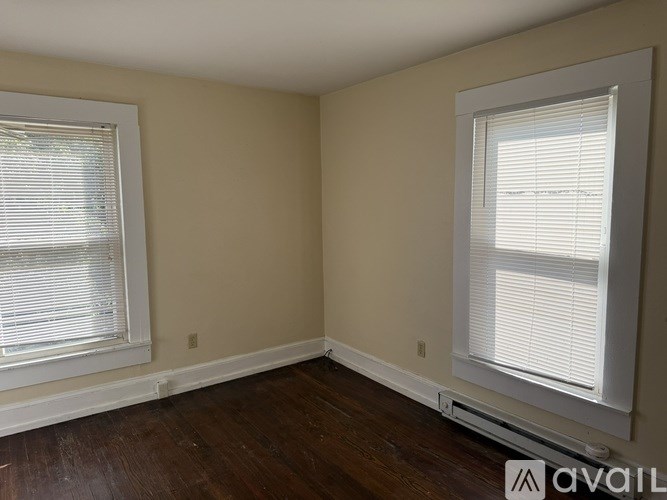 A room with a window on the left and another on the right.