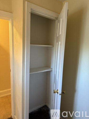 A white door with a shelf inside is open.