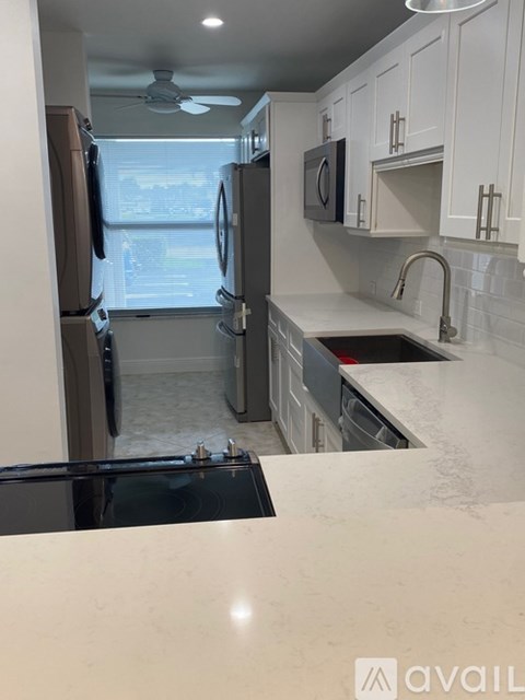 A kitchen with white cabinets and a black stove top.