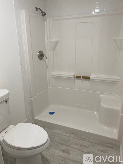 A white toilet sits next to a white bathtub in a bathroom.