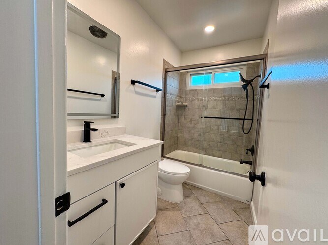 A bathroom with a toilet, sink, and shower.