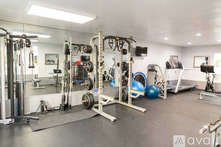 A gym with a variety of equipment including weights and machines.