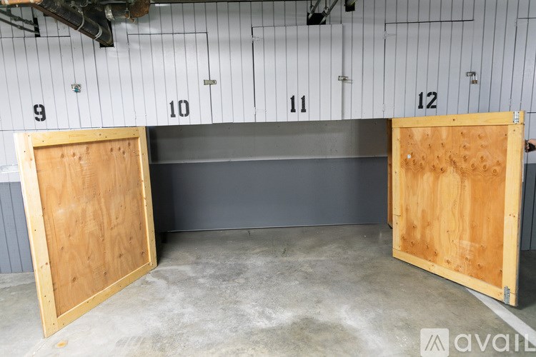 Two wooden doors are open in a room with white walls and numbered panels.
