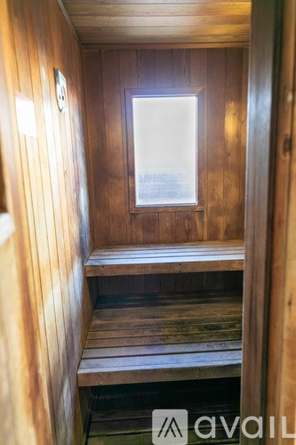 A wooden sauna with a window and a bench inside.